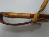 a close up of a wooden stick with a leather handle