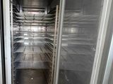 an empty freezer in the middle of a tiled floor