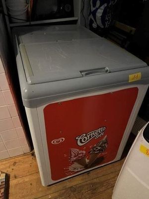 un petit réfrigérateur posé dans un coin d'une pièce