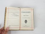 an open book with a hand holding it in front of it