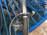 a close up of a blue umbrella with a sword on it