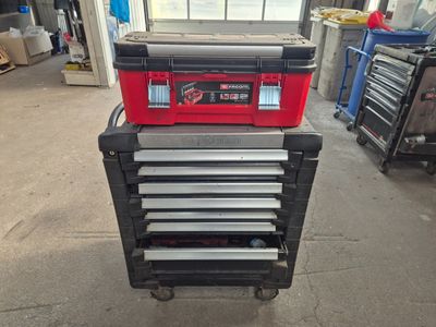 une boîte à outils rouge posée sur un chariot dans un garage