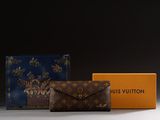 two louis vuitton wallets and a box on a table