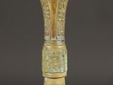 un vieux vase en bronze posé sur une table noire