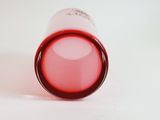 a close up of a pink lipstick bottle on a white surface