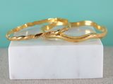 two gold rings sitting on top of a marble block