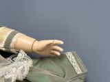 a doll that is holding a purse on a table