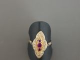 un gros plan d'une bague en or sertie d'un rubis au centre