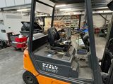a fork lift truck parked in a garage next to other vehicles