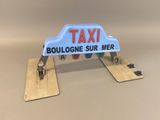 a taxi sign that is attached to a piece of wood