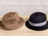 two hats that are sitting on a wooden table