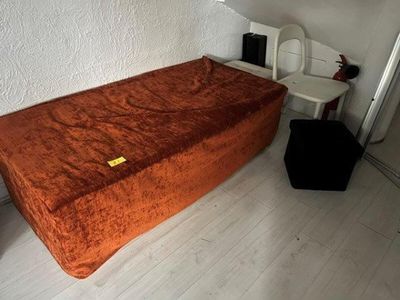 a small bed in the corner of a small room