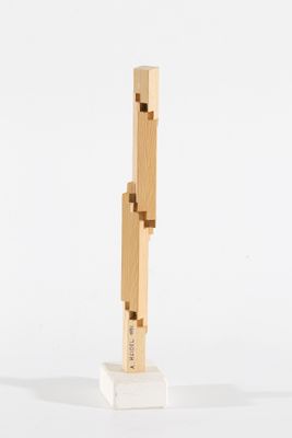 une petite sculpture en bois posée sur une surface blanche
