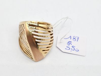 une bague en or posée sur une surface blanche