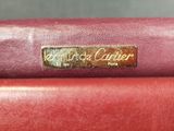 a close up of a red purse with a gold label on it