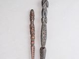 Deux objets métalliques sont posés l'un à côté de l'autre sur une surface blanche.