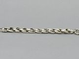 a close up of a silver chain bracelet on a gray surface
