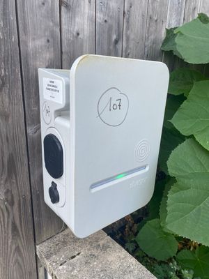 un appareil électronique blanc posé contre une clôture