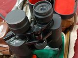 many pairs of binoculars sitting in a box on a table