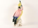 a figurine of a parrot sitting on top of a rock