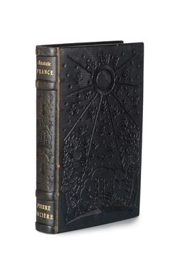 un vieux livre à la couverture noire posé sur une surface blanche