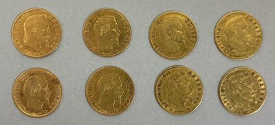 a group of six gold coins sitting on top of a white surface