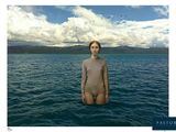 a woman standing in the middle of a body of water