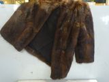 un manteau de fourrure marron accroché au mur d'un magasin