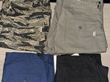 several pairs of men ' s pants sitting on top of a wooden table