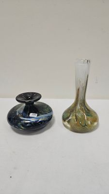 two glass vases sitting on top of a table next to each other