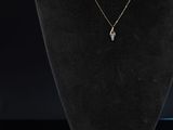 un collier et des boucles d'oreilles posés sur un mannequin devant un fond noir