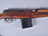 an old rifle with a wooden handle on a white surface