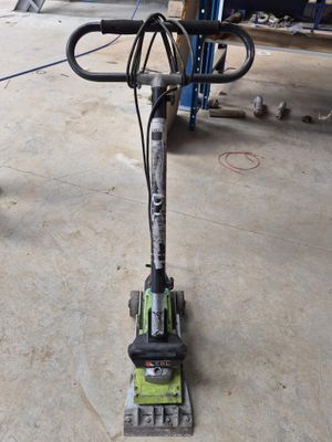 an image of a machine that is on the ground in a garage