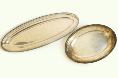 deux plateaux ovales en argent posés l'un à côté de l'autre