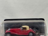 an old model of a red car in a glass case