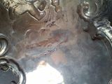 a silver plate with a design on it on a table