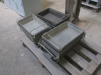 Plusieurs plateaux de nourriture sont empilés sur une palette dans un entrepôt