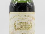 une vieille bouteille de vin posée sur une surface blanche