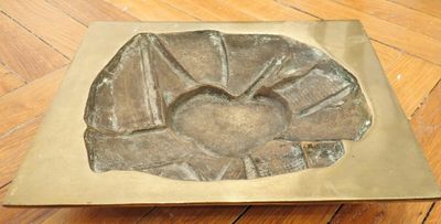 a metal object on a wooden floor that is shaped like a flower