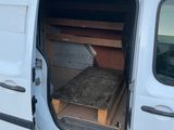 une camionnette blanche avec un lit à l'arrière