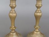 pair of antique brass candlesticks on a grey background