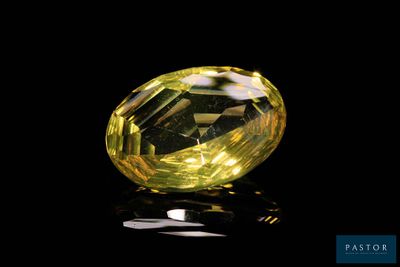 a close up of a yellow diamond on a black surface