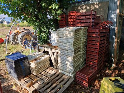 une pile de caisses posée sur une palette à côté d'un tracteur
