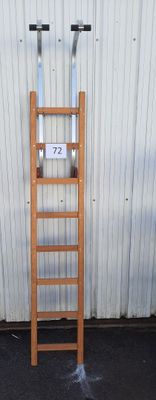 une échelle en bois appuyée contre un mur, sur laquelle figure un numéro