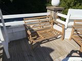two wooden chairs on the deck of a house