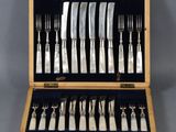 a set of silverware in a wooden case on a table