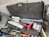 une mallette noire contenant des outils, posée par terre