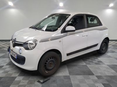 la petite voiture blanche est garée sur un carrelage à carreaux