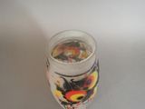 a glass with a flower design on it on a table
