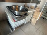 a large metal bowl on top of a stove in a kitchen